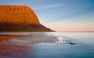 Beach mountain bodyofwater rockoutcrop sky - a mountain in the background and a body of water free wallpaper