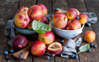 Bowl peaches blueberries wooden table - a wooden table free wallpaper