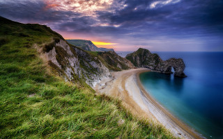 Beach cliff sunset cloudy sky - a cliff and a body of water free wallpaper