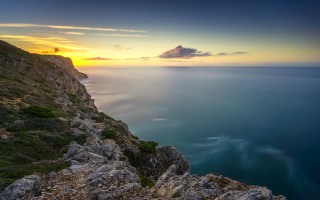 Sunset rocky cliff water mountain - a mountain in the distance free wallpaper