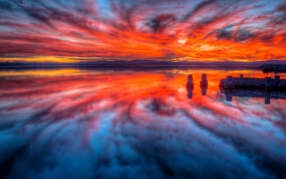 Colorful sunset lake clouds dock - a boat in the distance free wallpaper