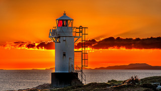 Lighthouse rocky shore sunset clouds 15 - radiant free wallpaper