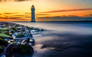 Lighthouse rocky shore sunset water 3 - a rocky shore free wallpaper