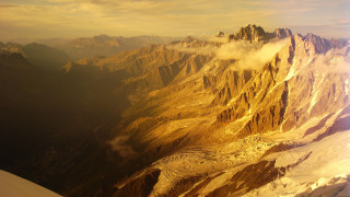 Mountain range plane window clouds - a view of a mountain range free wallpaper