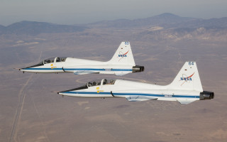 Two planes desert mountains skyline - the background and a sky line in the foreground free wallpaper