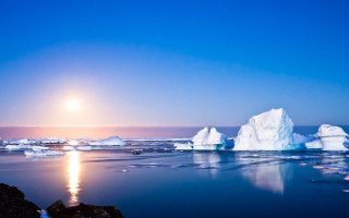 Iceberg ocean sun clouds lighthouse - a bright sun in the background free wallpaper