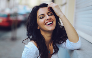 Smiling woman leaning wall jewelry - against a wall free wallpaper