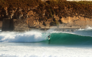 Surfer wave cliff beach city - a surfboard free wallpaper