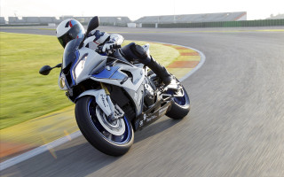 Motorcycle driving sunny day grass - the background and a building in the background free wallpaper