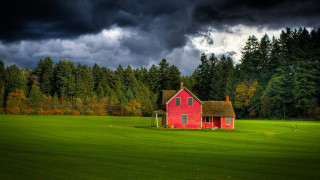 Red house field trees clouds - a dark sky in the background free wallpaper