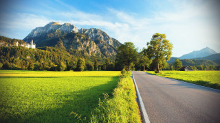 Green field road mountains clouds 2 - a green field free wallpaper