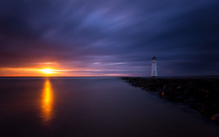 Lighthouse rocky shore sunset orange - radiant free wallpaper