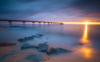 Sunset pier ocean rocks city - the foreground and a body of water free wallpaper
