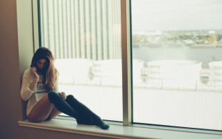 Woman window sill city tilt - a window sill free wallpaper