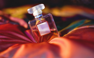 Perfume bottle red blanket hand 2 - a bottle of perfume free wallpaper