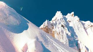 Snowboarder jumping mountain blue sky - a snowboard free wallpaper
