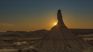 Desert rock formation sunset person - the sun setting behind free wallpaper