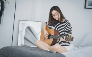Woman playing guitar bed room - a guitar in a room free wallpaper