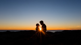 Sunset couple beach ocean silhouette - a couple standing next free wallpaper