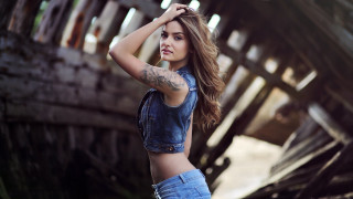 Tattooed woman front wooden background - her arm behind her head free wallpaper