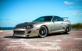 Silver sports car ocean beach - a brick road next free wallpaper