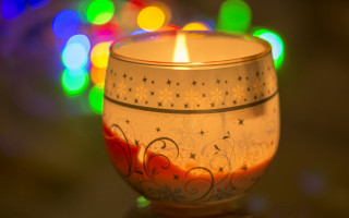 Lit candle colorful lights glass - top of a table next free wallpaper
