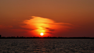 Sunset water boat tower mountain - a sunset over a body of water free wallpaper