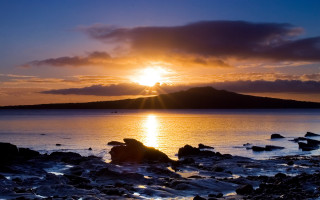 Sunset water rocks mountain city - a sun setting free wallpaper