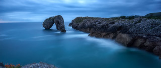 Long exposure rock formation ocean - a body of water below free wallpaper