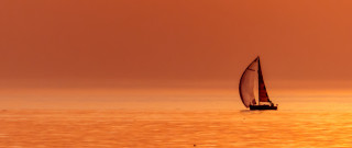 Sailboat ocean sunset red sky - a sailboat free wallpaper