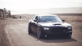 Black car driving road grass 4 - a black car free wallpaper
