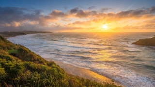 Sunset ocean beach cliff cityscape - a sunset over the ocean free wallpaper