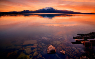 Mountain lake rocks sunset cityscape - the foreground and a sunset in the background free wallpaper