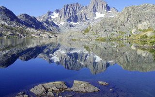 Mountain reflection lake rocks grass 2 - the foreground and a mountain range in the background free wallpaper