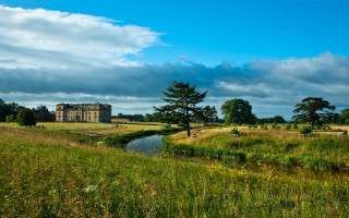 Lush green field house river - a large house free wallpaper
