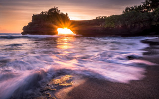 Sunset beach waves rocks island - a small island in the distance free wallpaper