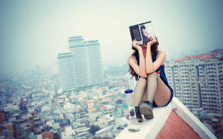 Rooftop cityscape woman reading iphone - tall free wallpaper