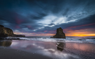 Beach rocks sunset clouds city - widescreen free wallpaper