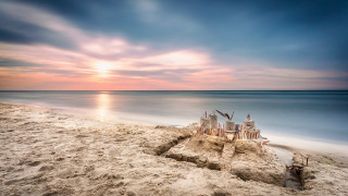 Sandcastle beach sunset water landscape - a sunset in the background and a body of water free wallpaper