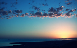 Sunset water plane clouds beach - a sunset over a body of water free wallpaper