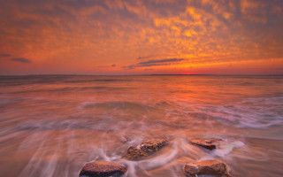 Sunset ocean rocks clouds beach - a sunset over the ocean free wallpaper