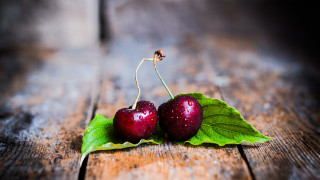 Cherries green leaves wooden table - a wooden table free wallpaper