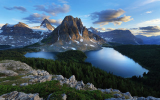 Mountain lake forest rocks sky 2 - the foreground and a mountain range in the background free wallpaper