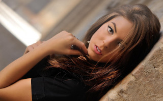 Woman portrait serious browneyes longhair - a woman leaning against a wall free wallpaper