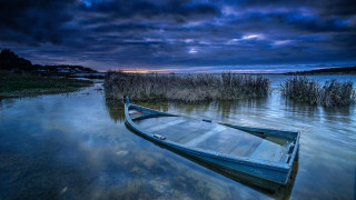 Dusk boat water city lights - a dark sky in the background free wallpaper