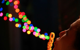Young girl blowing out lights - a string of lights free wallpaper