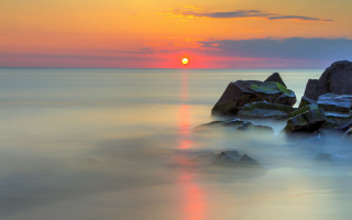 Sunset ocean rocks orange sun - a few cloud free wallpaper