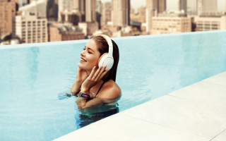 Woman pool headphones smiling cityscape - headphone free wallpaper