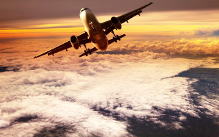 Large jetliner cloudy sunset ocean - a cloudy sky above the clouds free wallpaper