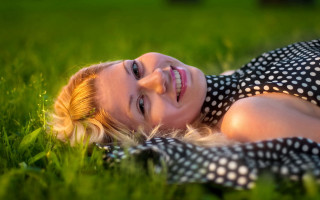 Woman smiling laying grass bokeh - a bun free wallpaper